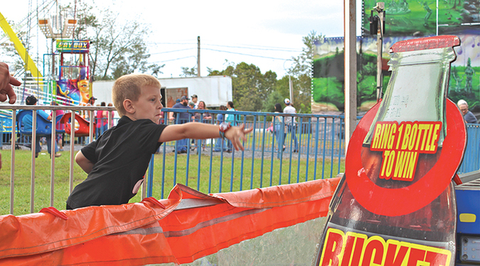 Gavin Hagerman tries his hand at the ring toss last weekend during the county fair.  KENNETH CROWSON PHOTO